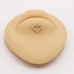 Macro detail of heart-shaped labret jewelry with inlaid pearls and sparkling crystals
