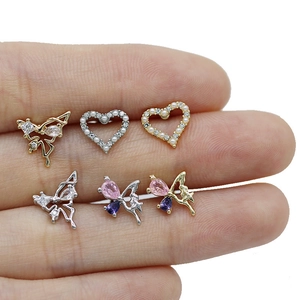 Close-up of small heart and butterfly labret studs with colorful teardrop zircon gems