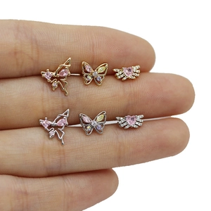 Close-up of six colorful butterfly and heart labret studs displayed on a finger