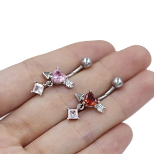 Detalle macro de piercings de ombligo de corazón con piedras rosas y rojas y circonitas