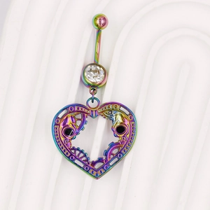 Macro-opname van regenboog navelpiercing met hartvormig steampunk tandwiel en schedel