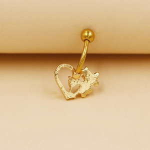Detalle de un piercing de ombligo dorado en forma de corazón con textura de relieve