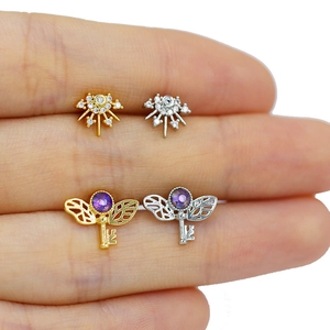 Detailed macro view of tiny crown and purple key studs held in hand for size context