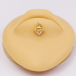 Golden heart navel piercing with pink stone and thorn design on silicone model