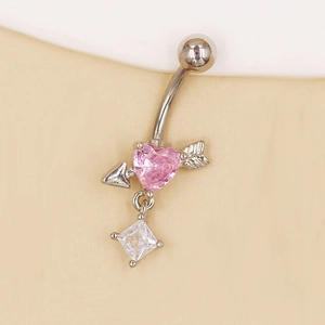 Detalle macro de piercing de ombligo con flecha de Cupido, corazón rosa y cristal
