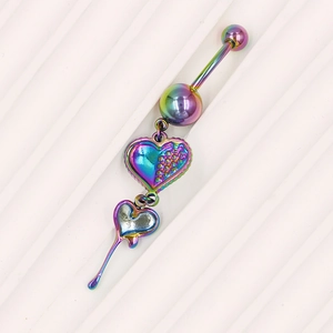 Macro-opname van een regenboogkleurige dubbele hart navelpiercing op witte achtergrond