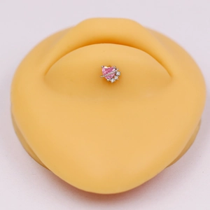 Macro view of pink heart-shaped cubic zirconia navel ring on medical grade steel
