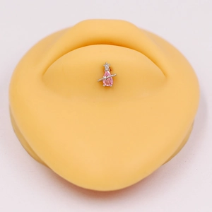 Detailed view of pink pear-shaped zircon Saturn lip stud on a skin-tone silicone model