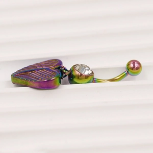 Macro-opname van regenboog navelpiercing met hartvleugel hanger en heldere zirkonia