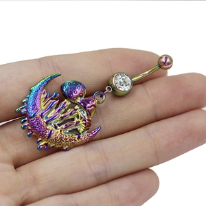 Macro-detail van regenboogkleurige navelpiercing met maan en paddenstoel met witte zirkoon