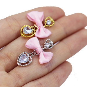 Detalle de colgante de lazo rosa con circonita de corazón y base en color oro o plata
