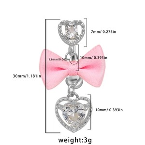 Vista de detalle del piercing de ombligo con circonita corazón, lazo rosa y medida 30mm