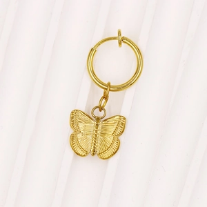Detailansicht eines goldenen Bauchnabelrings mit einem detaillierten Schmetterlingsanhänger
