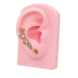 Set de cinco pendientes con circonitas rosas y blancas y dijes de alas en modelo de oreja