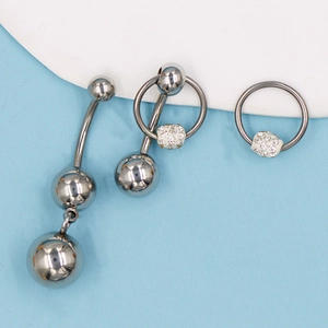Vista detallada del set de piercing de acero inoxidable plateado con colgante de cristal