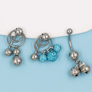 Tres piercings de ombligo de acero inoxidable con brillantes azules y cascabeles