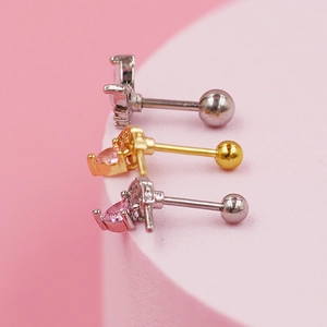 Detalle macro de pendientes de corazón en plata, oro y oro rosa con circonita rosa