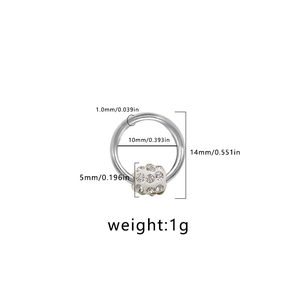 Primer plano de un piercing de ombligo de acero inoxidable con bola de strass brillante