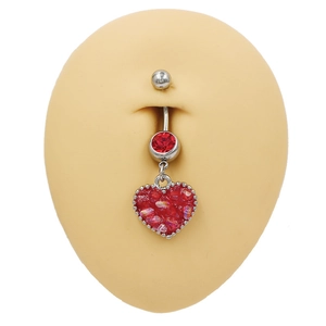 Detalle del piercing de ombligo de corazón con colgante de rubí rojo en maniquí