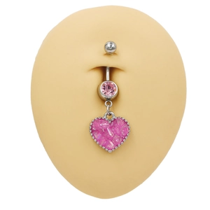 Piercing de ombligo plateado con colgante de corazón rosa sobre modelo de silicona