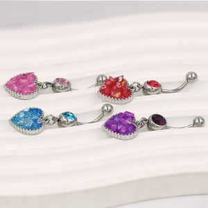 Detalle de cuatro piercings de ombligo de corazón con incrustaciones de piedras de color