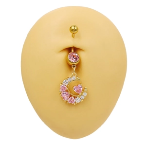Détail d'un piercing de nombril lune dorée avec pendentif coeur en zircon rose