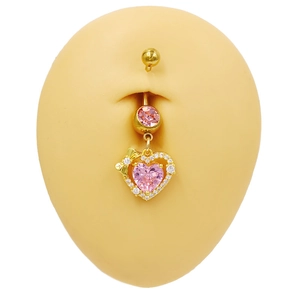 Détail d'un piercing nombril coeur en cristal rose avec noeud doré et pavé blanc