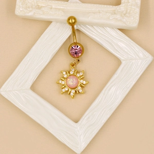 Détail d'un piercing de nombril doré avec cristal rose et pendentif opale soleil