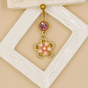 Détail de piercing nombril fleur de cerisier doré avec pierres roses et diamants