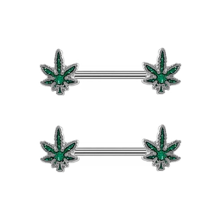 Macro shot of stainless steel barbell nipple rings with green clover leaf leaf design