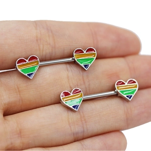 Macro detail of rainbow heart-shaped nipple rings with vibrant oil-drip stripes and steel bar