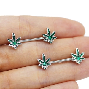 Detailed view of silver stainless steel nipple rings with green glitter leaf motifs