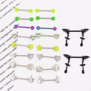 Detailed close-up of 18 green and gothic nipple ring sets on a white background paper