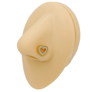 Dettaglio di un piercing al naso a cuore dorato con cristalli su un modello in silicone