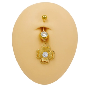 Makro-Detail des goldenen Kleeblatt-Bauchnabelpiercings mit Zirkonia am Modell