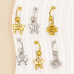 Detailansicht von sechs Bauchnabelpiercings mit Schmetterlings- und Kleeblattmotiven