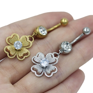 Detail von Kleeblatt-Bauchnabelpiercings in Gold und Silber mit matter Textur