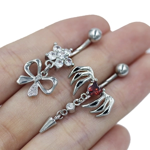 Detail van navelpiercings met zirkoon bloem en rode hartvleugel ontwerpen