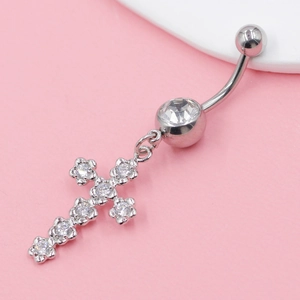 Macro shot of silver stainless steel cross belly ring with sparkling zircon stones