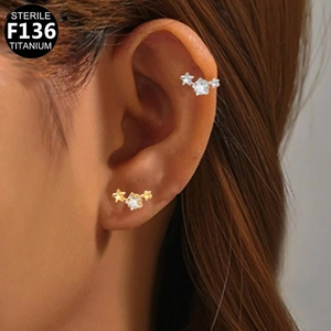 Sterile F136 titanium triple star stud earrings with cubic zirconia on ear lobe