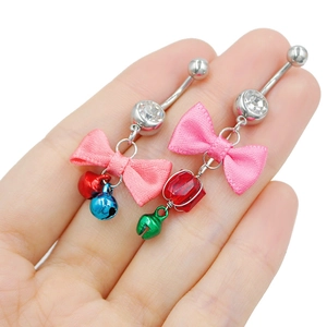 Detailed macro view of handmade belly button rings with pink silk bows and colorful bells