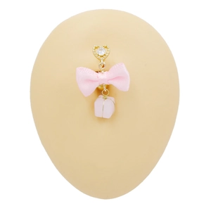 Detail of pink bow and gift box charm on a golden heart belly piercing ring