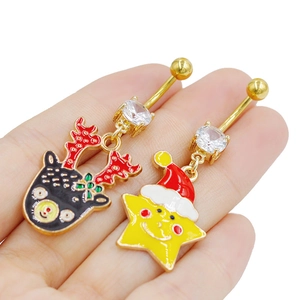Detalle de piercings de ombligo navideños con reno y estrella dorados y con circón