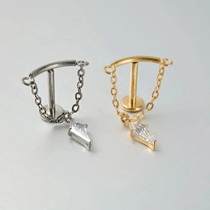 Macro detail of G23 titanium chain earrings with marquise zircon in silver and gold finish
