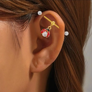 Golden industrial barbell earring with ladybug pendant and white pearl accents