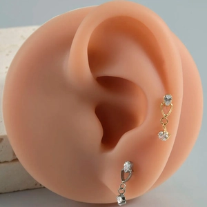 Detail of G23 titanium dangling heart earrings with zircon studs on ear model