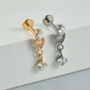 Detail of G23 titanium labret studs with pear-shaped zircon and hanging chain tassels