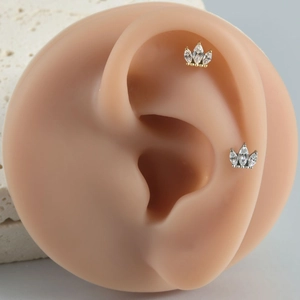 Détail de boucles d'oreilles couronne en titane avec zircons cubiques de taille marquise