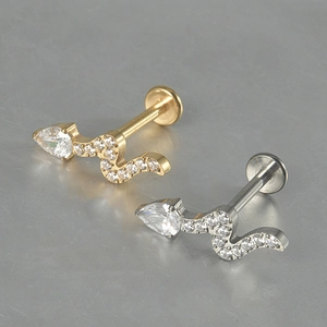 Detailed view of snake-shaped titanium studs with inlaid zircons in gold and silver
