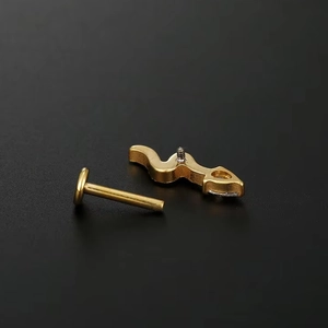 Detailed view of G23 titanium labret stud with golden finish and clear zircon inlay